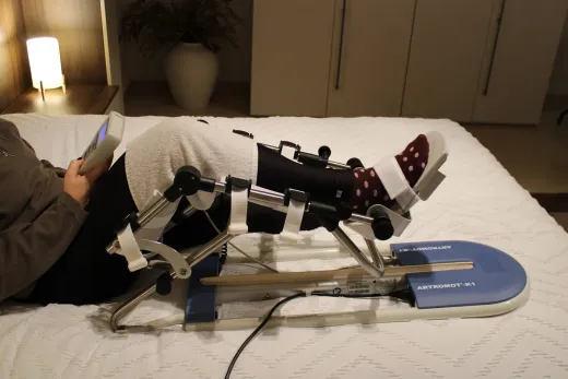 Artromotor colocado en la pierna izquierda durante una sesión de movilización pasiva en cama